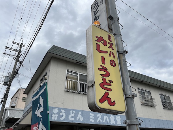 「ミヅハのカレーうどん」の看板が店先に立っている